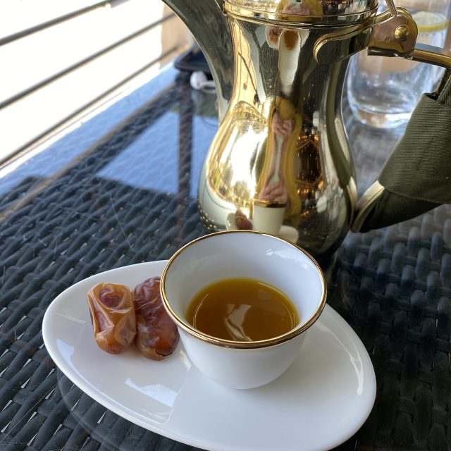 قهوة عربية في فنجان مع تمر ودلة ذهبية