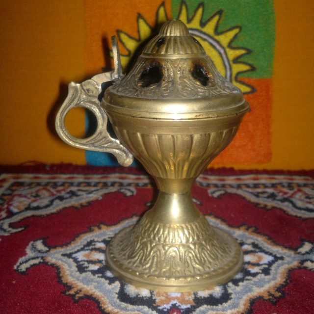 مبخرة نحاسية مزخرفة على سجادة حمراء