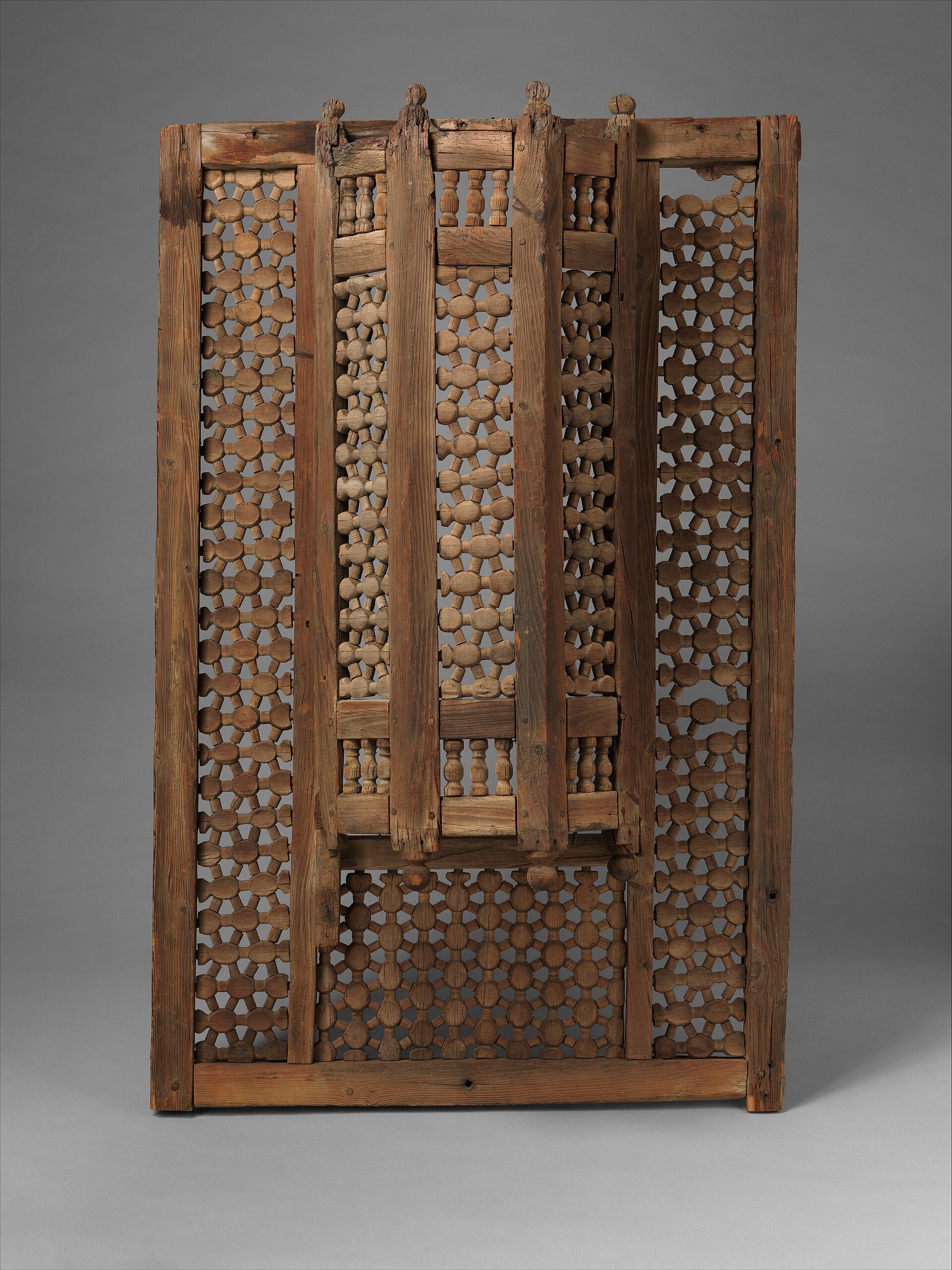 A turned-wood mashrabiya screen in a wooden frame