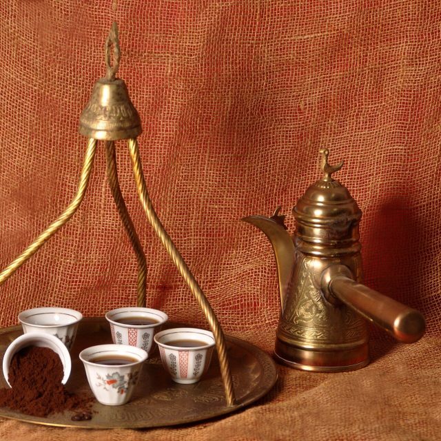 صينية نحاسية عليها فناجين وحامل ودلة صغيرة